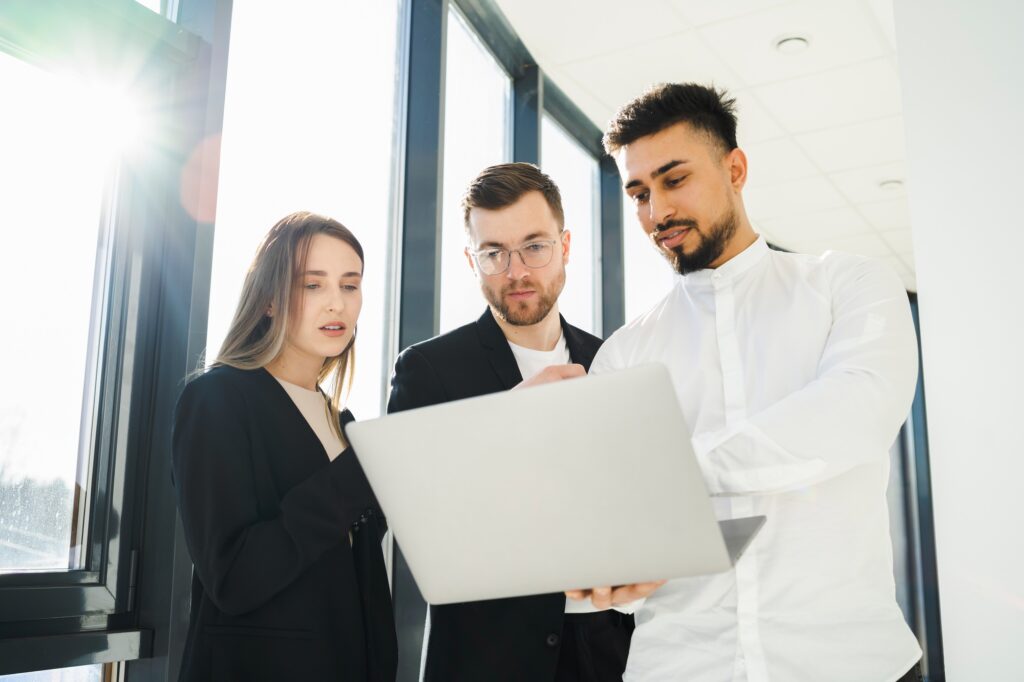 Group of business people in the office looking at a laptop consulting about a new project