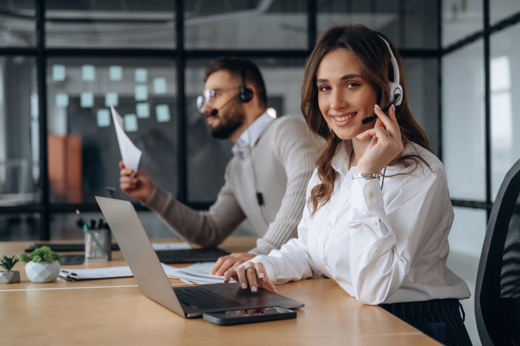 Service of call center support team. Man and woman are working in the office